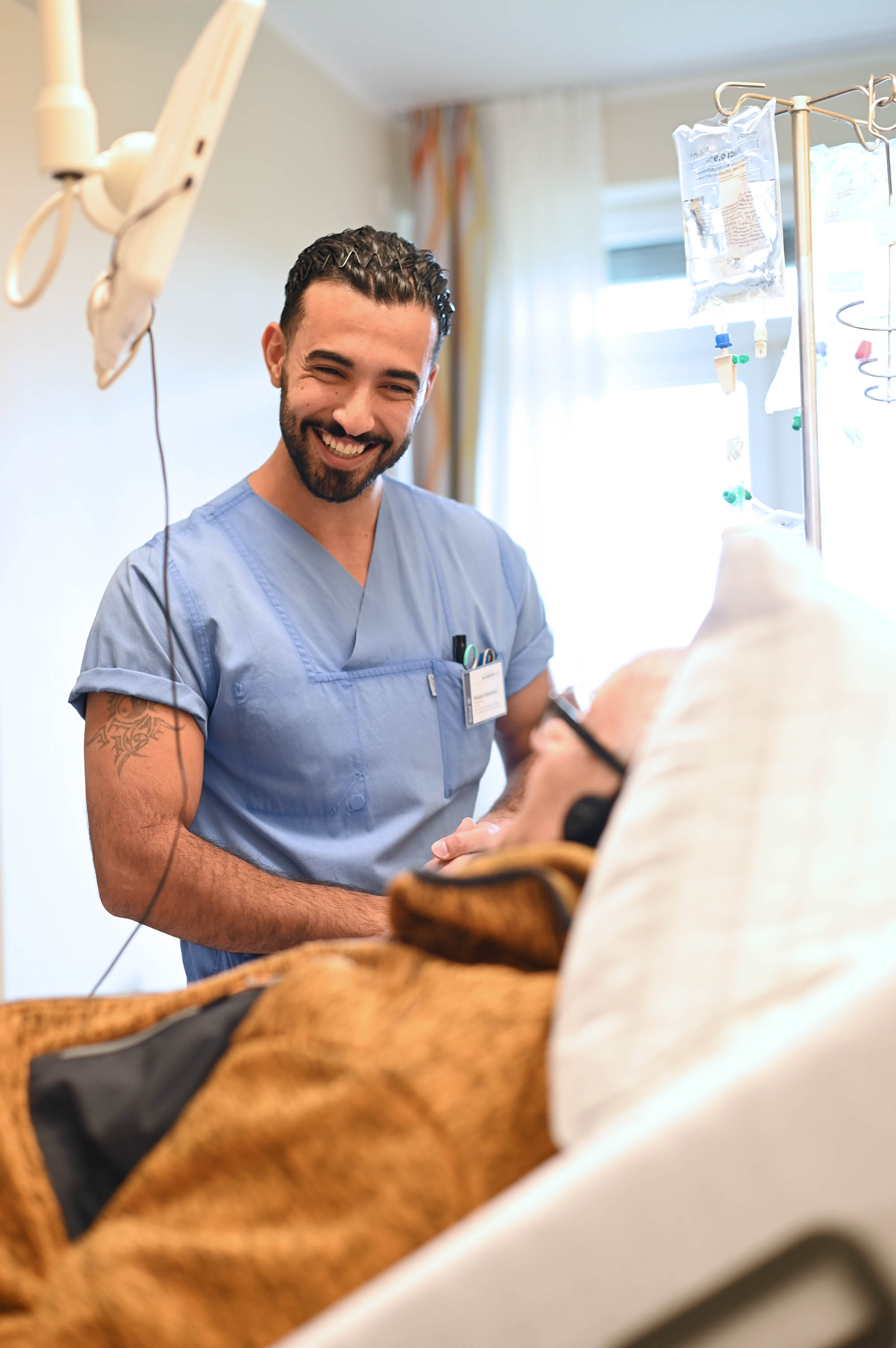 Eine männliche Pflegekraft in Interaktion mit einem Patienten.